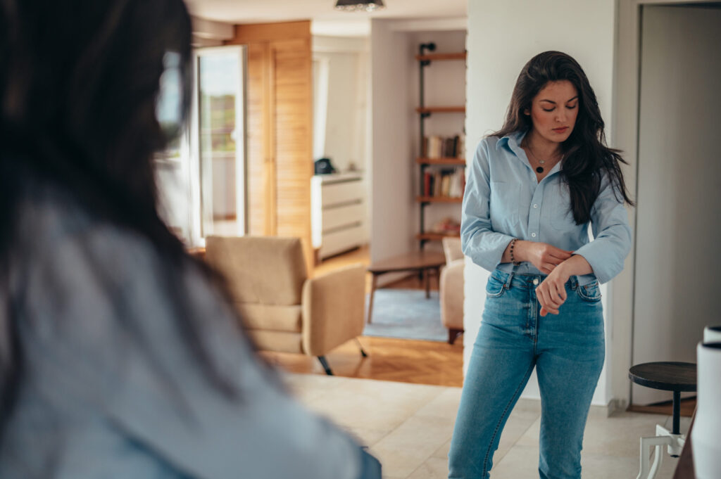 young white businesswoman getting dressed for work while still at home in the morning