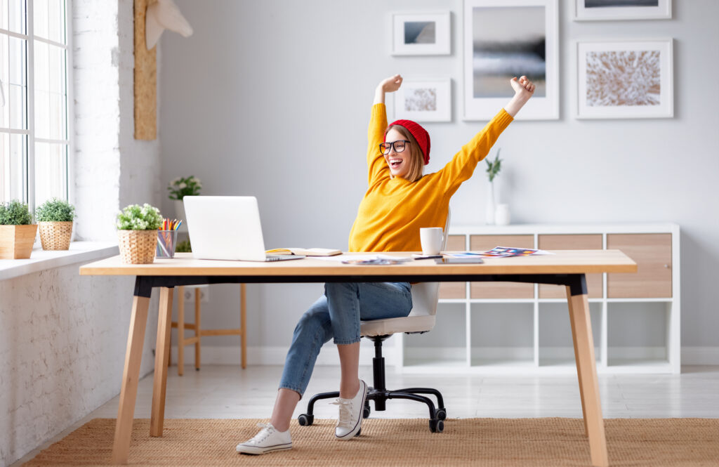 girl in red beret excited at her desk working her remote job