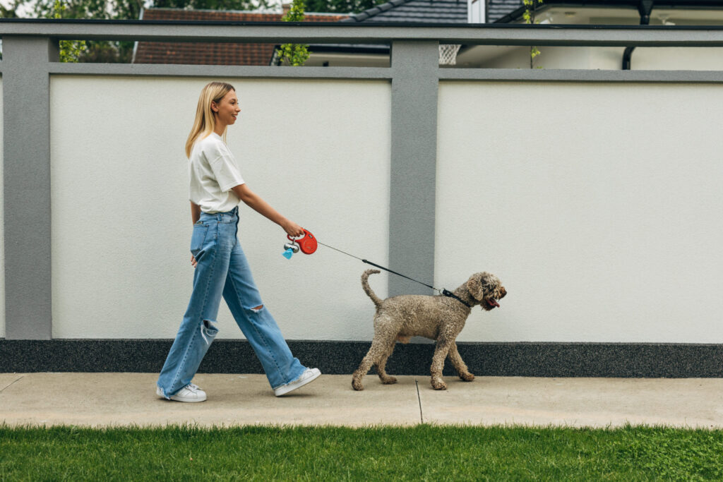 blonde woman taking the dog for a walk