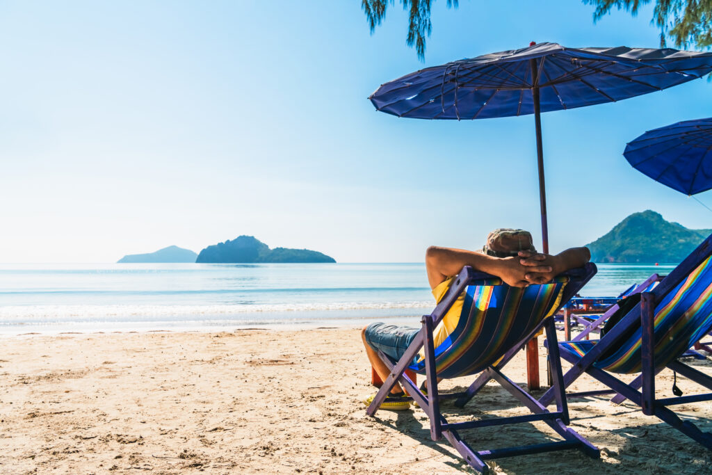 traveler relaxing on beach chair in front of vacation exotic beach