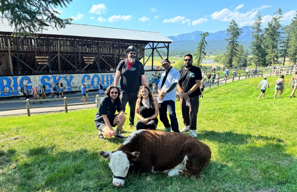 leap team members posing in front of cow at Under the Big Sky