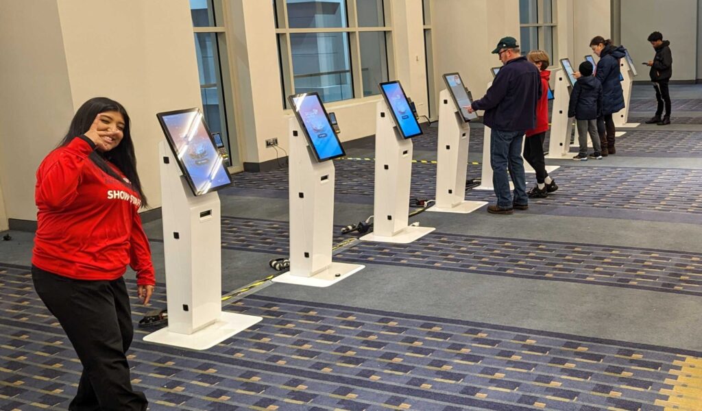 leap team member posing in front of kiosks