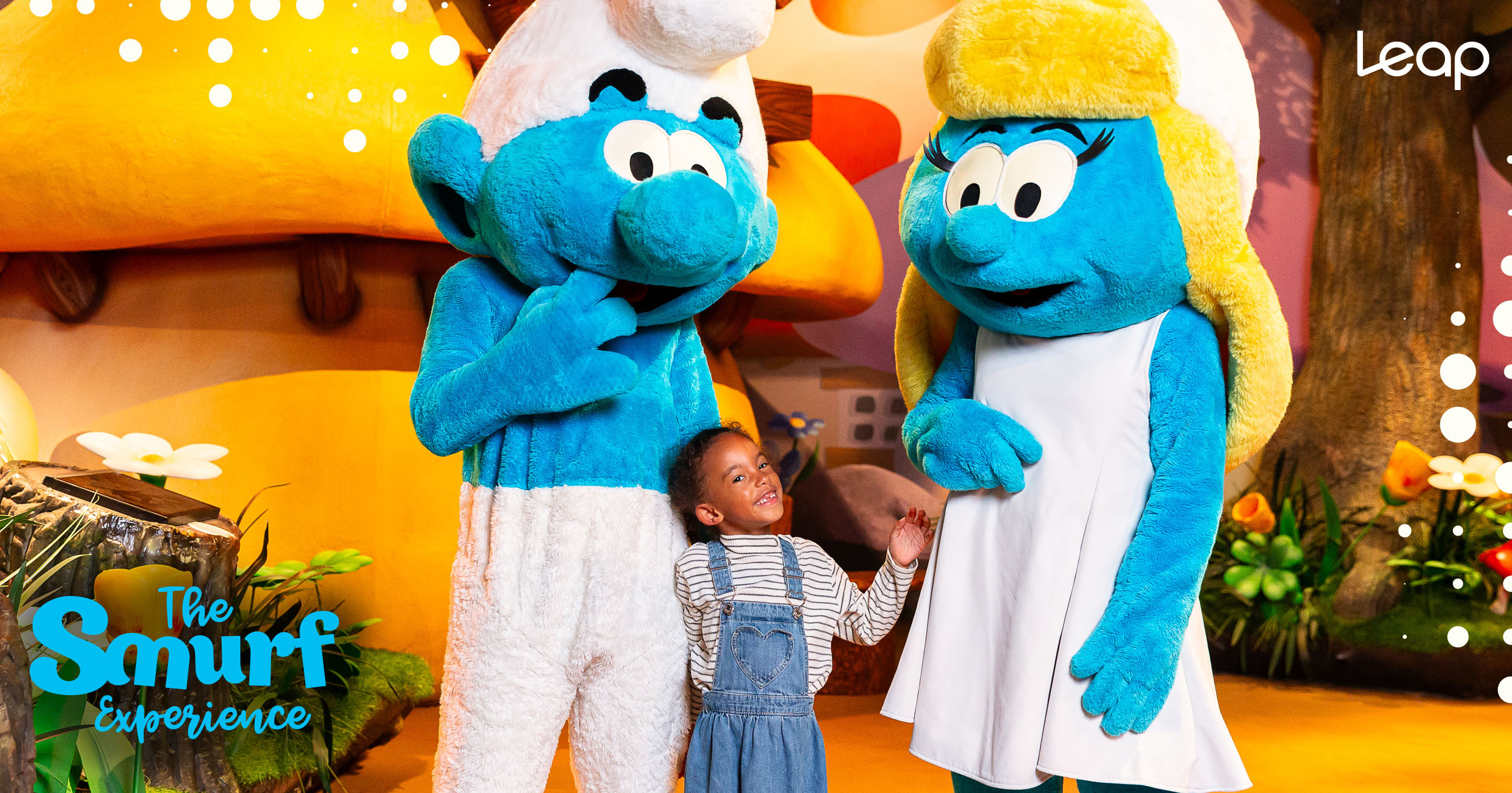 A young girl standing and smiling between Timid Smurf and Smurfette
