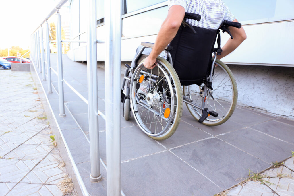 Young man in wheelchair on ramp outdoors