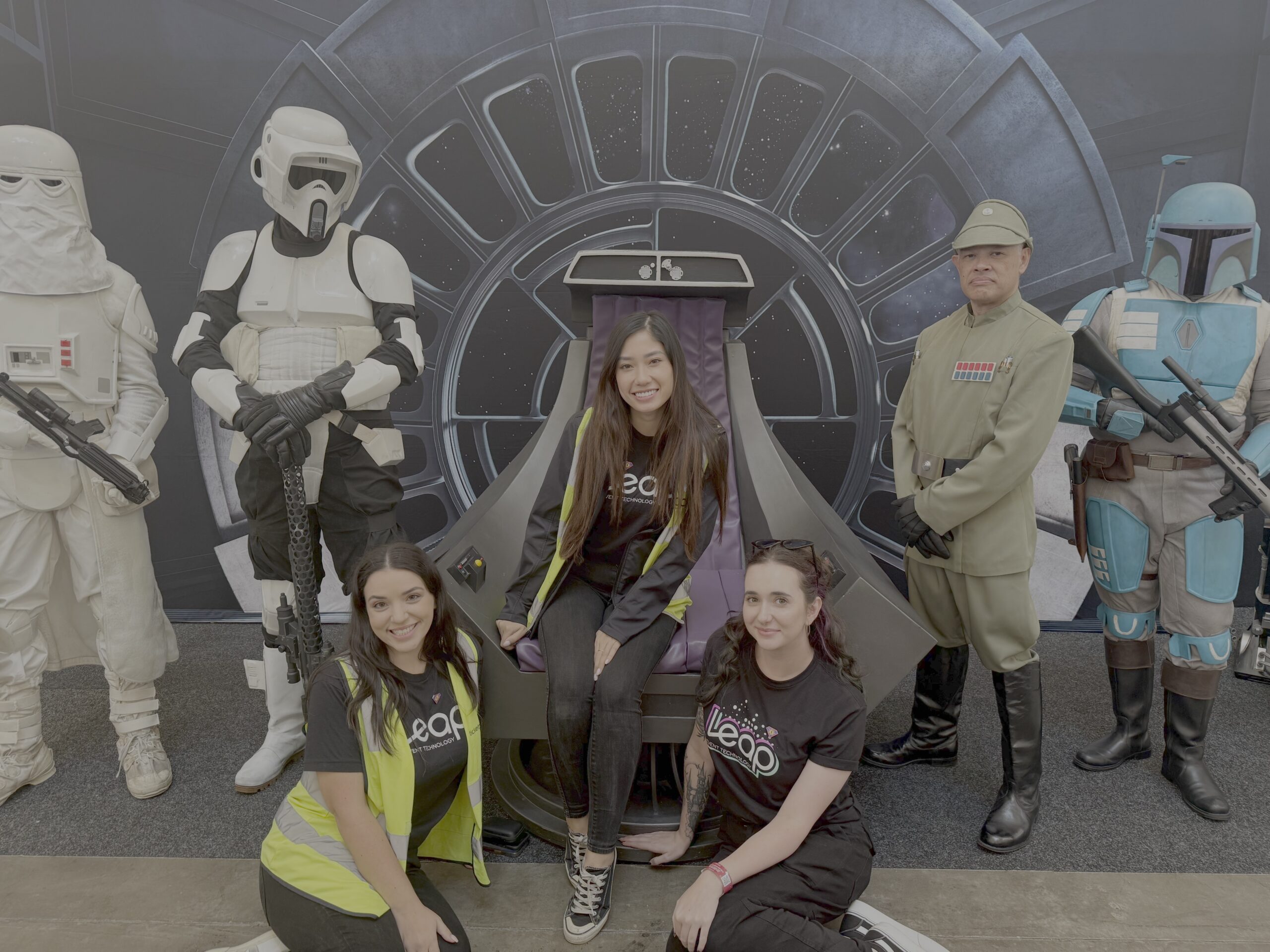 three Leap team members posing in front of a Star Wars backdrop at a comic con