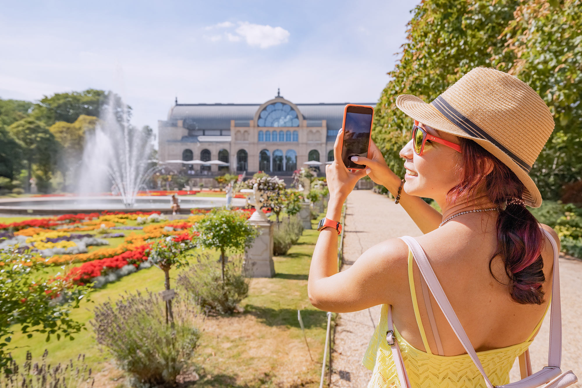 A girl taking a photo outside of a botanical garden