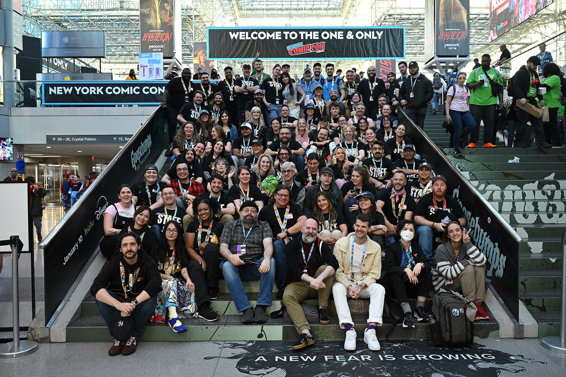 A photo of a large group of New York Comic Con goers sitting on a staircase together