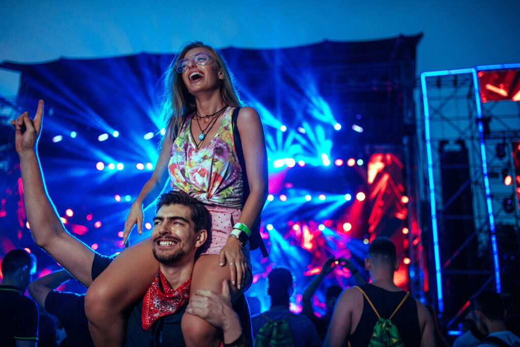 girl on a guy's shoulders at a music festival