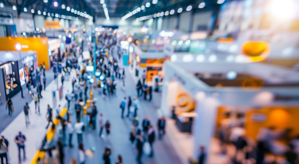 crowded conference floor at a trade show with lines of vendors