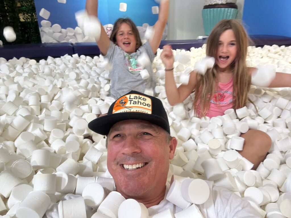 mike playing with his kids in a marshmallow pit